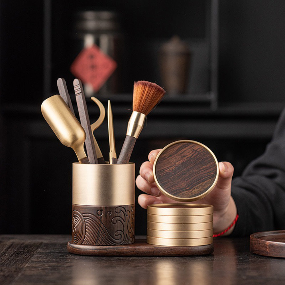 Close-up of ebony and copper tea utensils set with coasters, showcasing craftsmanship and materials