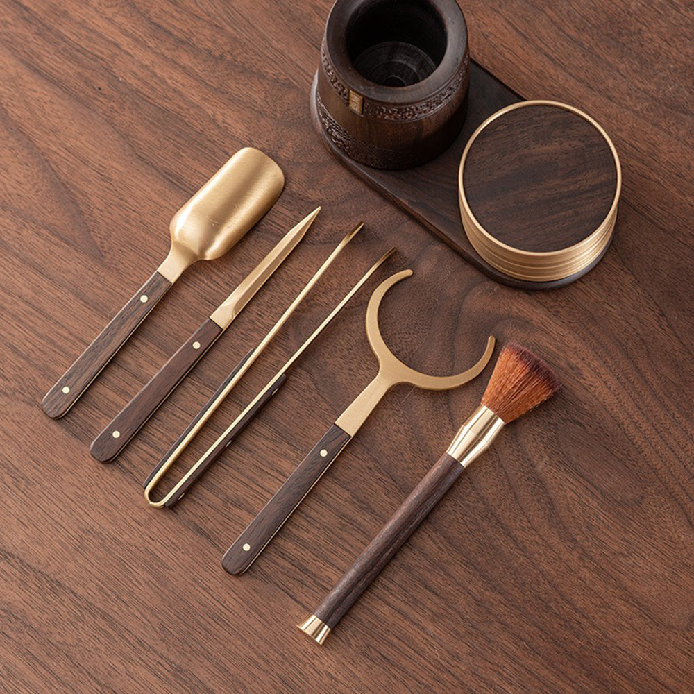Detailed view of copper-inlaid coasters and ebony tea utensils for gifting