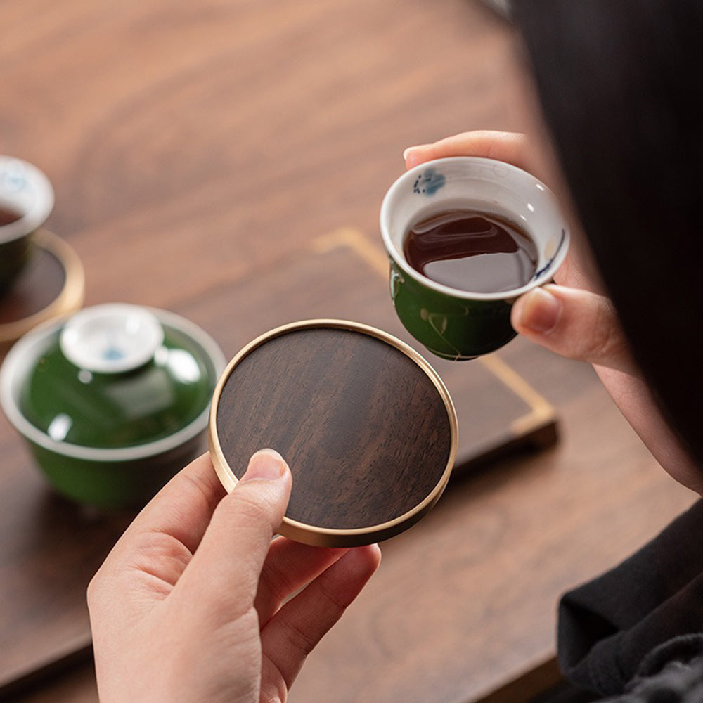Ebony tea set with copper coasters and traditional carvings, ideal for tea ceremonies