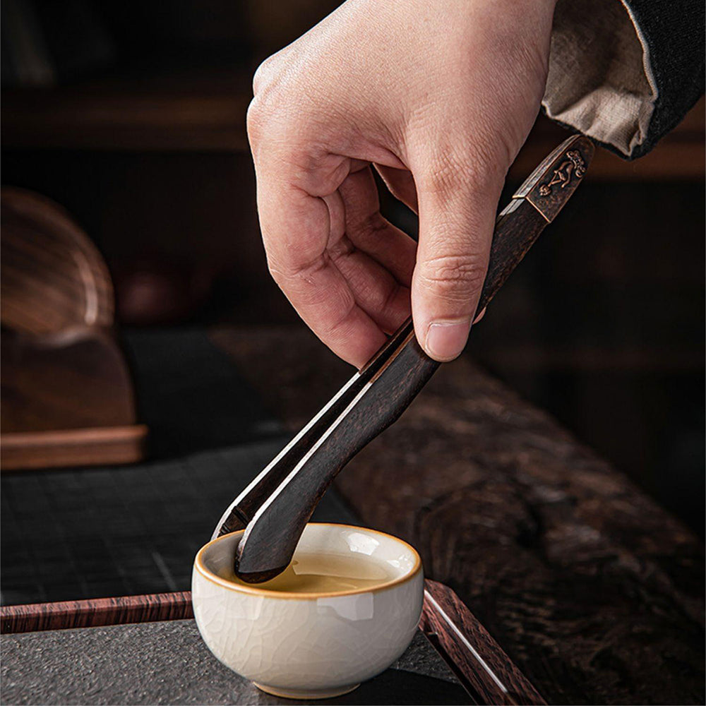 Tea ceremony setup with walnut tea utensils set, cups, and coasters in a serene tea environment
