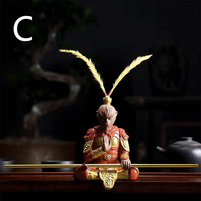 Ceramic Wukong figurine sitting cross-legged with golden hoop stick, detailed and colorful for tea decor