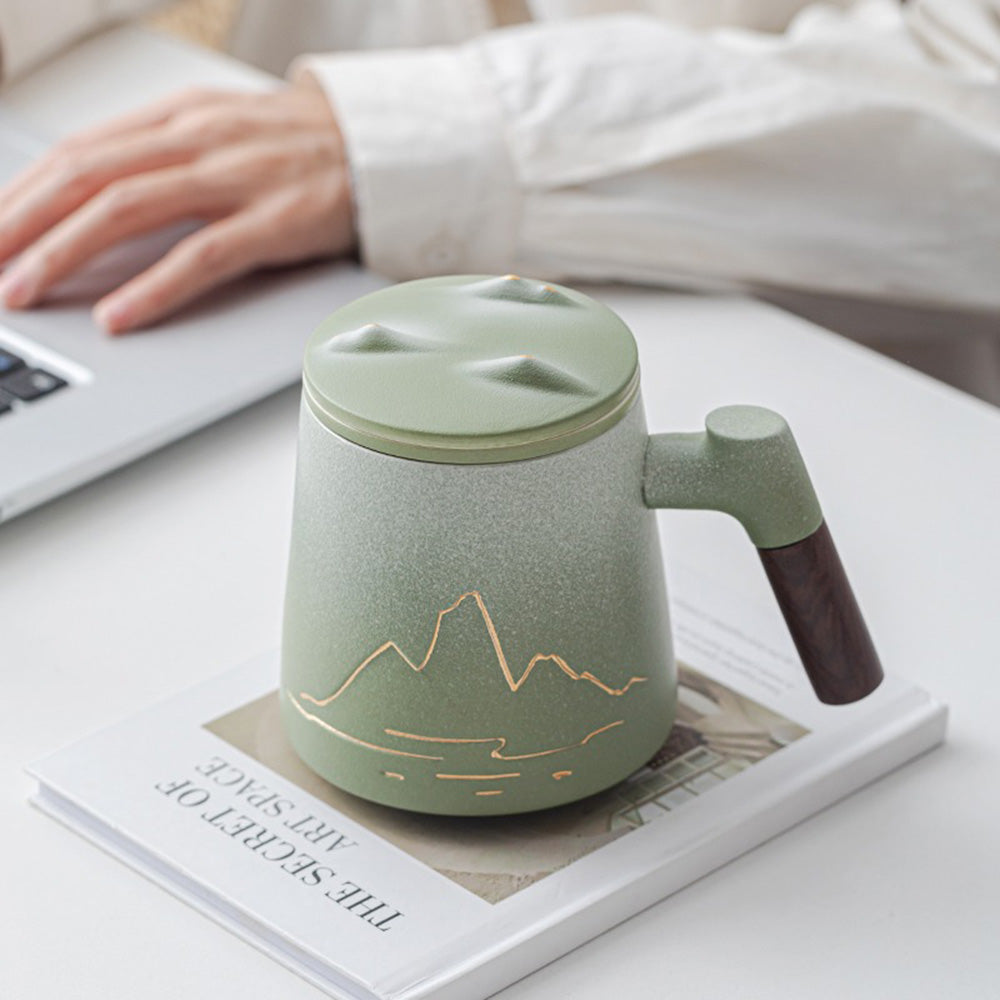 Close-up of the handmade ceramic tea cup with relief mountain design and frosted texture