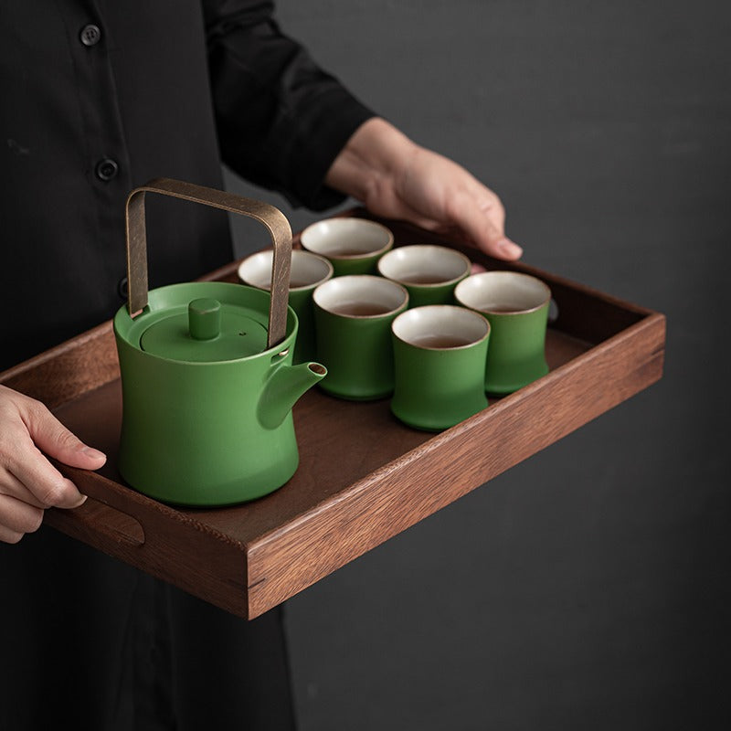 Elegant Green Bamboo Tea Set arranged on a table with tea and flowers