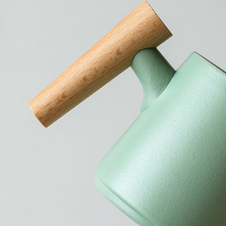 Japanese tea being poured into ceramic cup with wooden handle for a refined tea experience