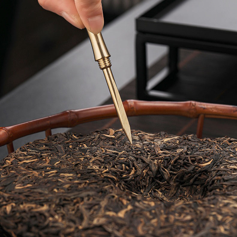 Copper tea tools including spoon, funnel, and tweezers for authentic Gong fu tea