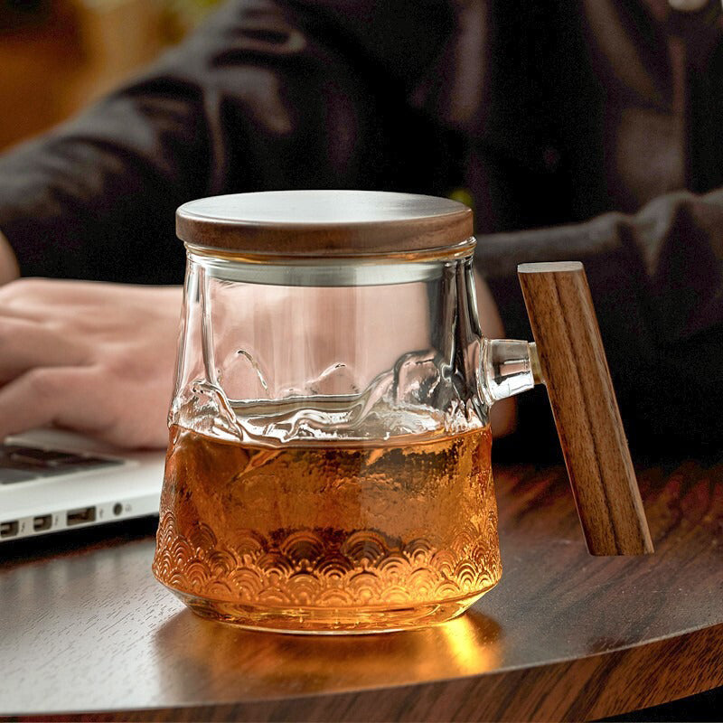 Elegant borosilicate glass tea mug with wooden lid from a side angle