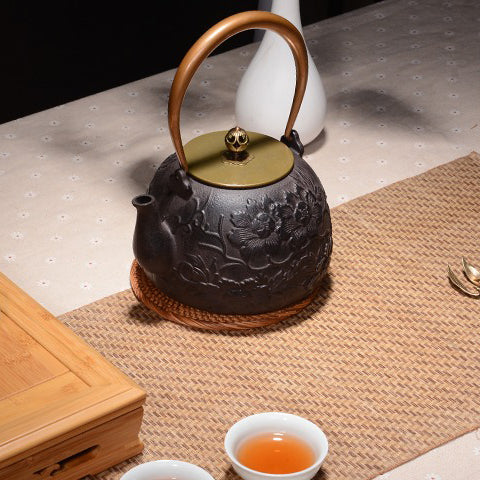 Close-up of the peony carvings on the cast iron teapot, emphasizing craftsmanship and beauty.