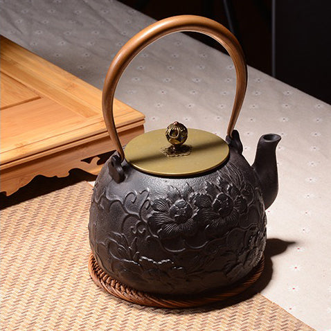 Angle view of the elegant peony cast iron teapot with rose gold handle, showcasing its intricate design.