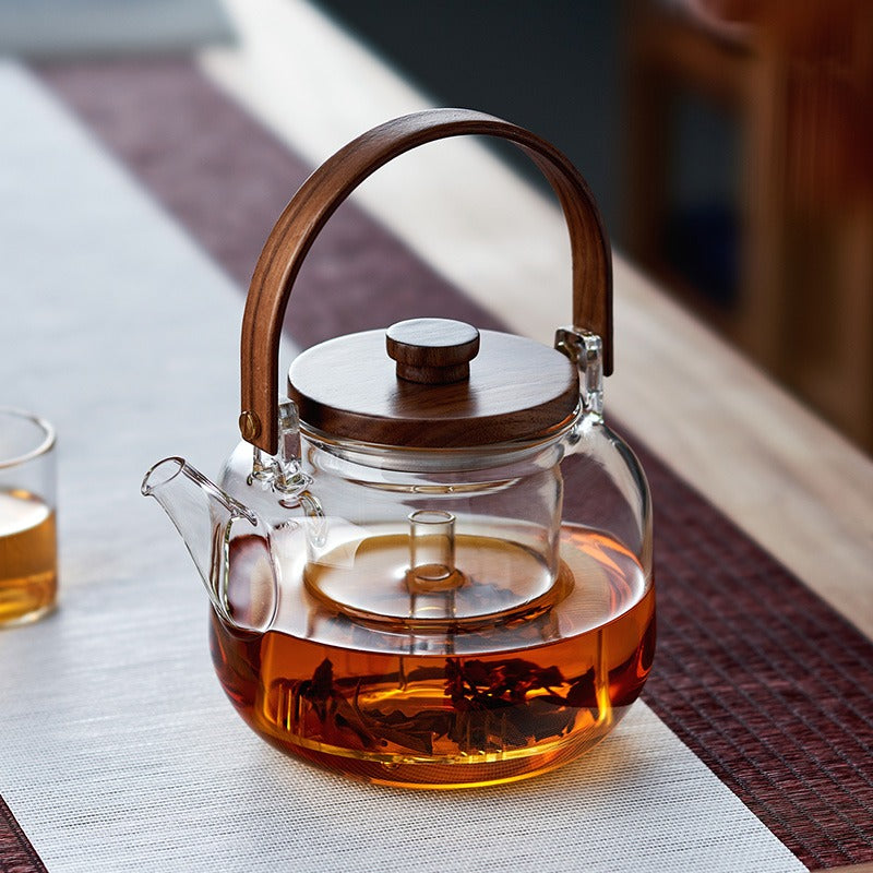 Close-up of the glass teapot with steam infuser, highlighting its craftsmanship.