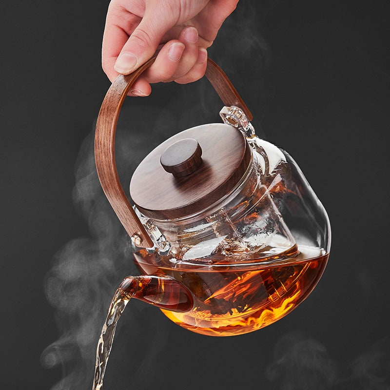 Elegant glass teapot on a teapot warmer, perfect for enjoying hot tea.