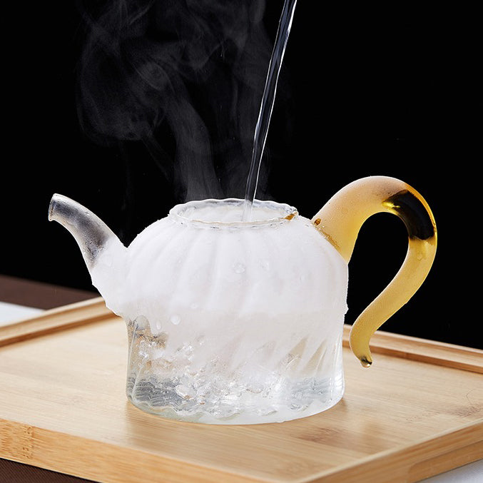 Close-up of the petal-shaped lid and ergonomic handle of the glass teapot, designed for comfort and safety.