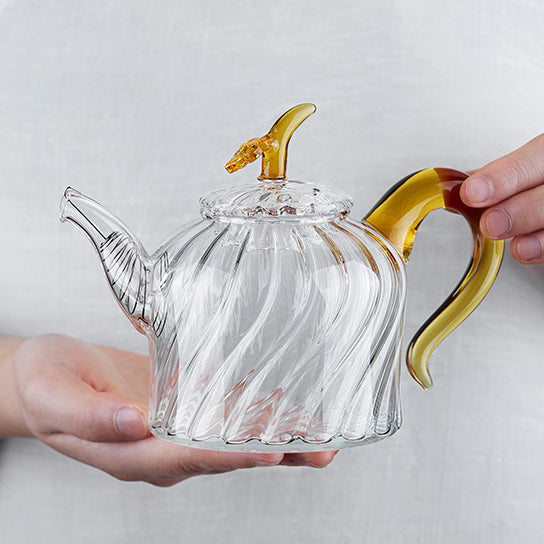 Elegant borosilicate glass teapot with a spiral texture and stainless steel strainer, showcasing its heat resistant features.