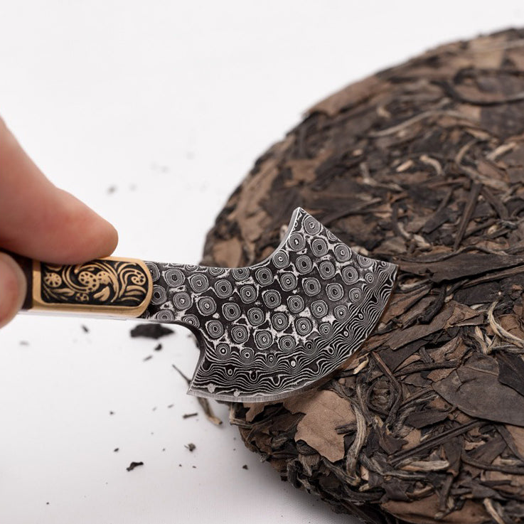 Close-up of the artisan puerh tea cake axe cutter against a wooden background, showcasing its solid wood handle and stainless steel blade.
