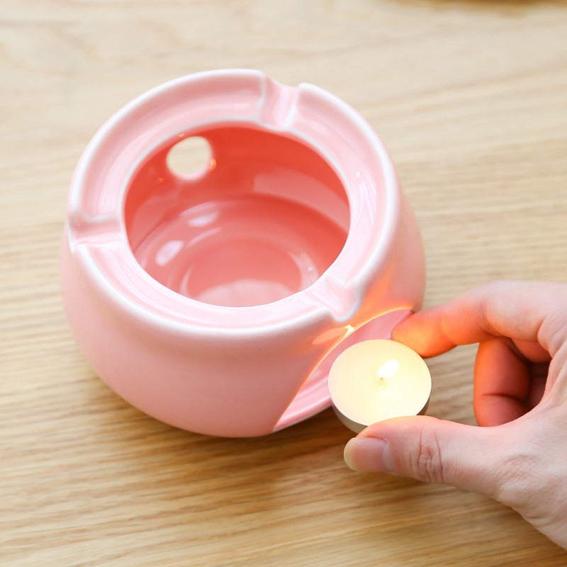 Close-up of the glass teapot with built-in filter and tea cups in a cozy setup