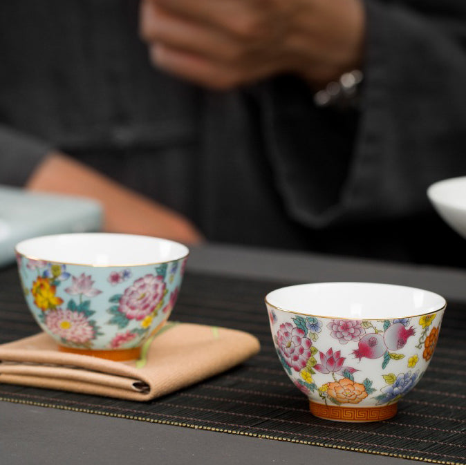 Close-up of high-quality enamel tea cups showing gold edges and vibrant colors.