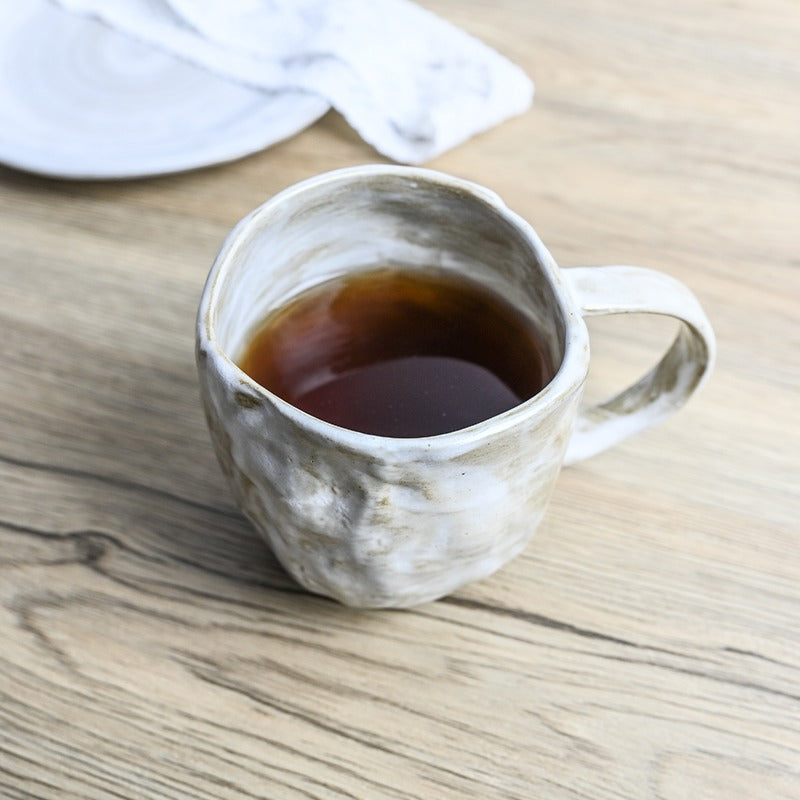 Close-up of ceramic tea mug with tea leaves and filter