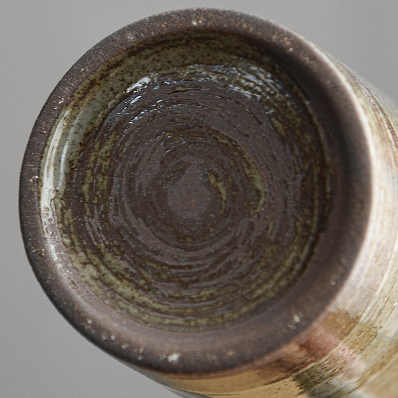 Close-up of the vintage Japanese ceramic mug showcasing its unique glaze and wooden handle.