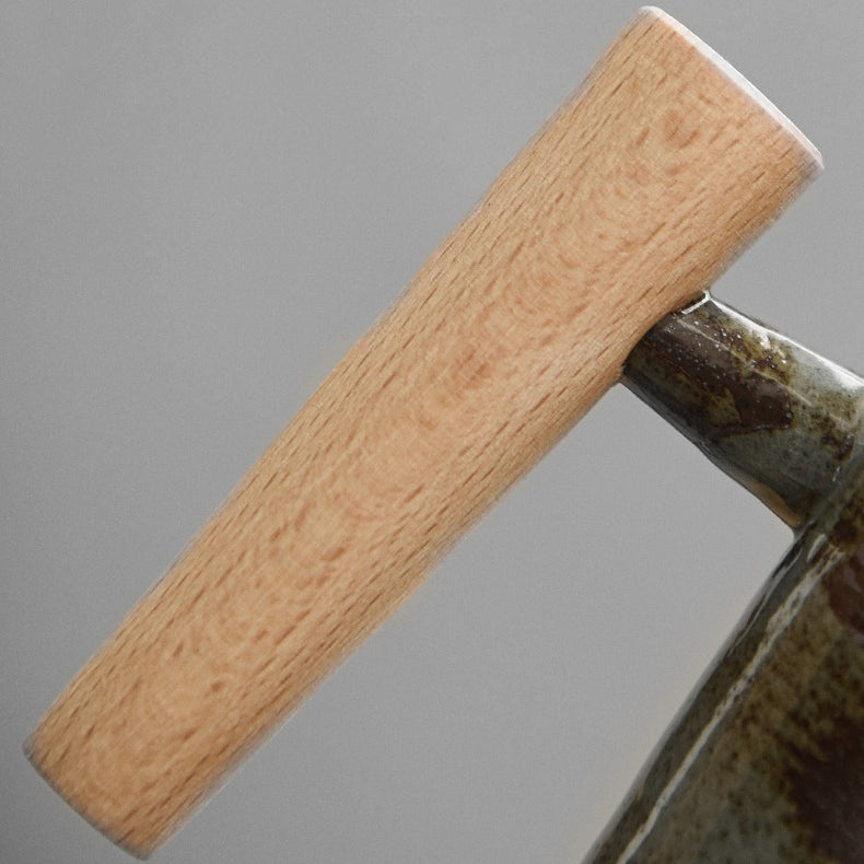 Close-up of the vintage Japanese ceramic mug showcasing its unique glaze and wooden handle.