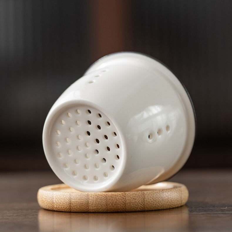 Tea accessories including a cup, strainer, and travel bag, ideal for traveling