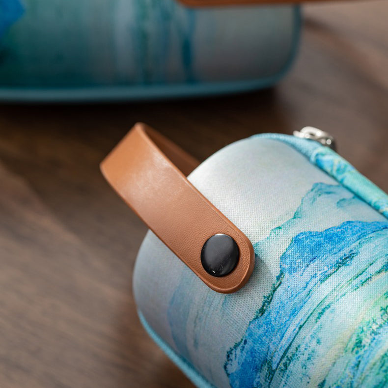 Travel tea set with strainer and wooden base on outdoor table, perfect for camping trips