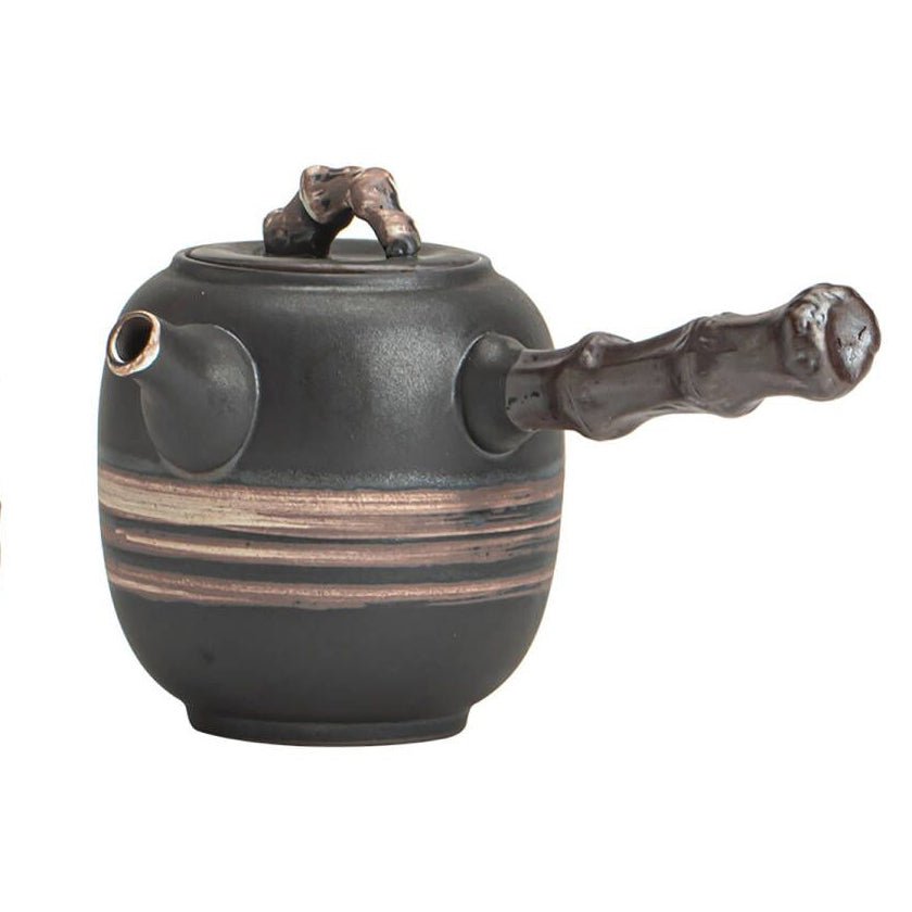 Close-up view of the wabi-sabi teapot's black and white texture with bamboo handle