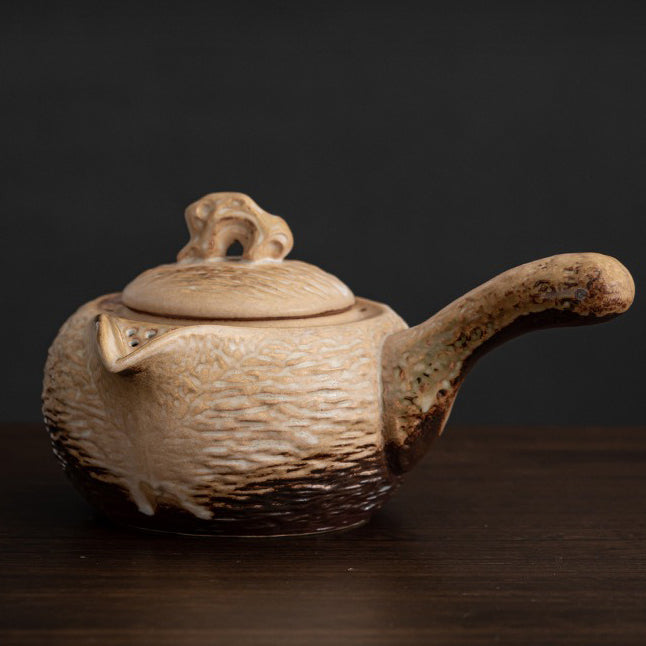 Close-up of the heated teapot showcasing its stone-like texture and ergonomic handle.
