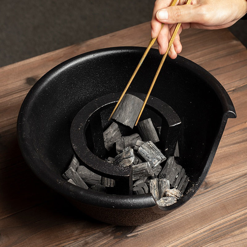 Cast iron tea cooker set displayed with a teapot and tea spoon, highlighting its durable features.