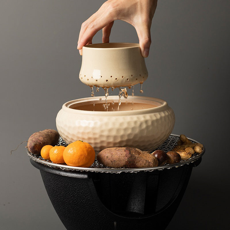 Cast iron tea cooker set displayed with a teapot and tea spoon, highlighting its durable features.