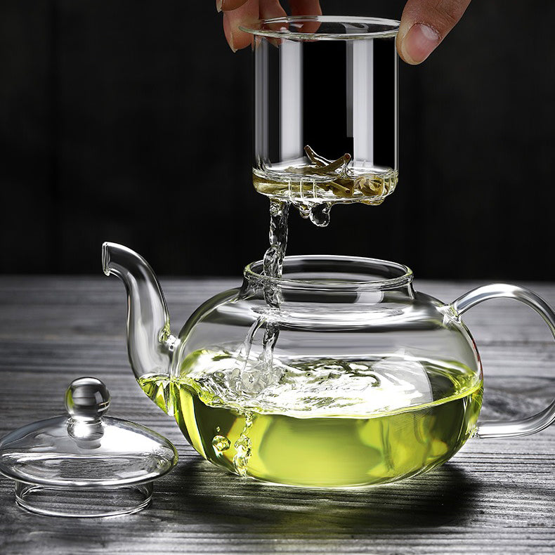 Pouring hot herbal tea from the glass teapot with a smooth spout, highlighting its elegant design