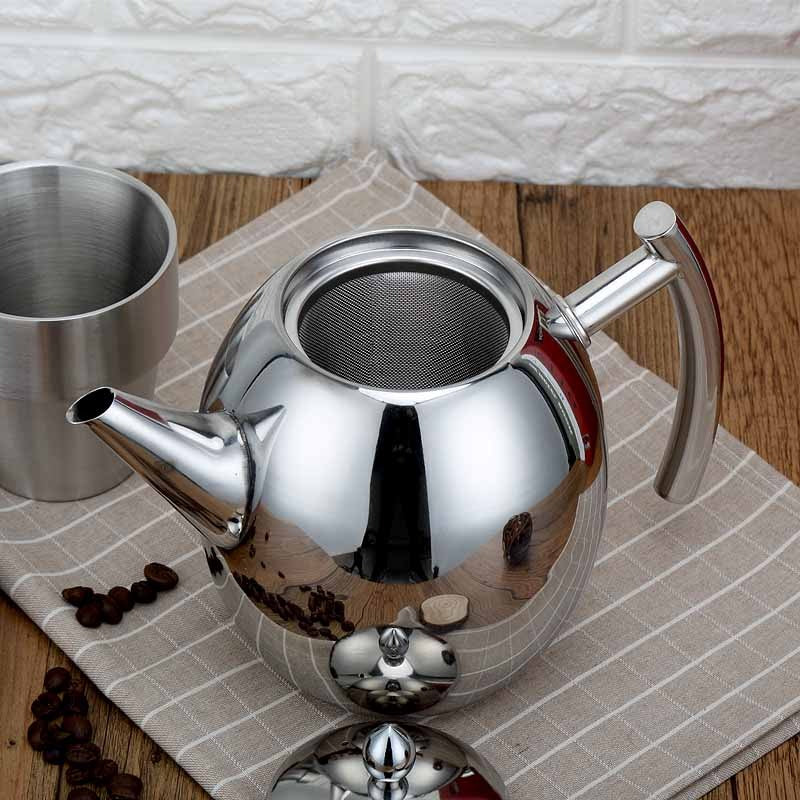 A close-up of the stainless steel teapot in use, pouring tea into a cup, demonstrating its functionality.