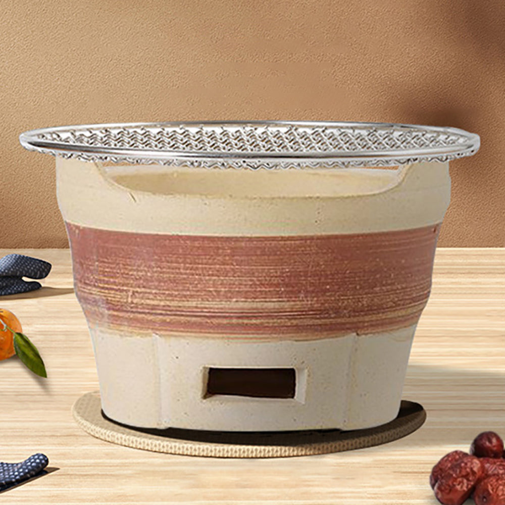 Close-up of the charcoal tea stove showcasing its durable rough clay material and stable design.