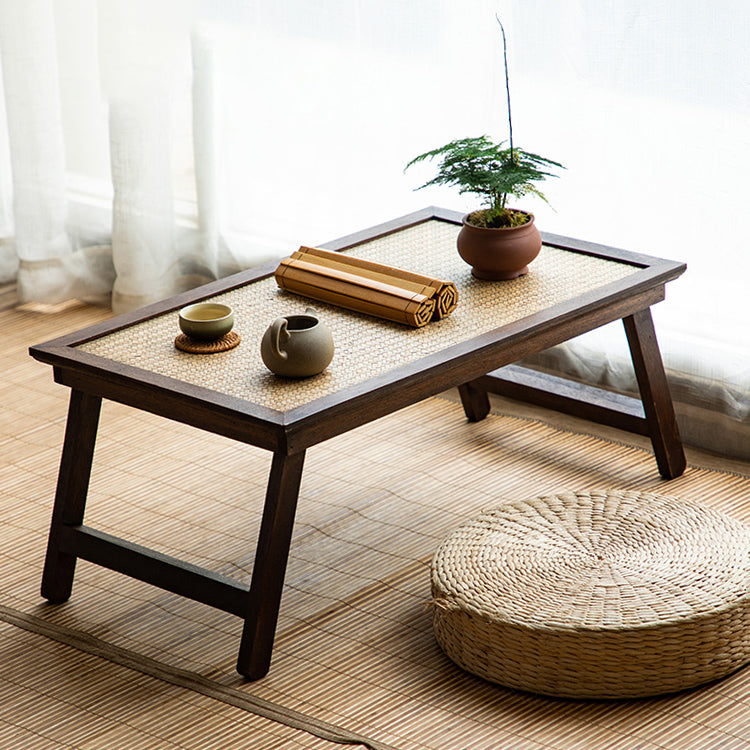 Elegant foldable rattan tea table set up for a tea ceremony in a cozy living room.