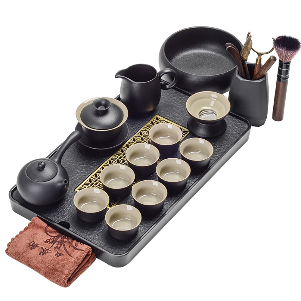 Elegant black ceramic side handle teapot with matching cups on a slate tray.