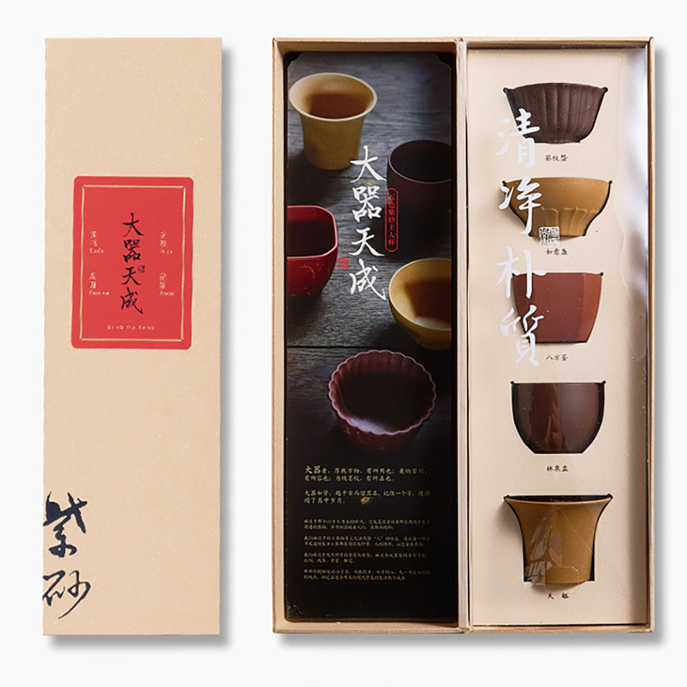 Set of colorful purple clay Yixing tea cups with intricate shapes and gift box