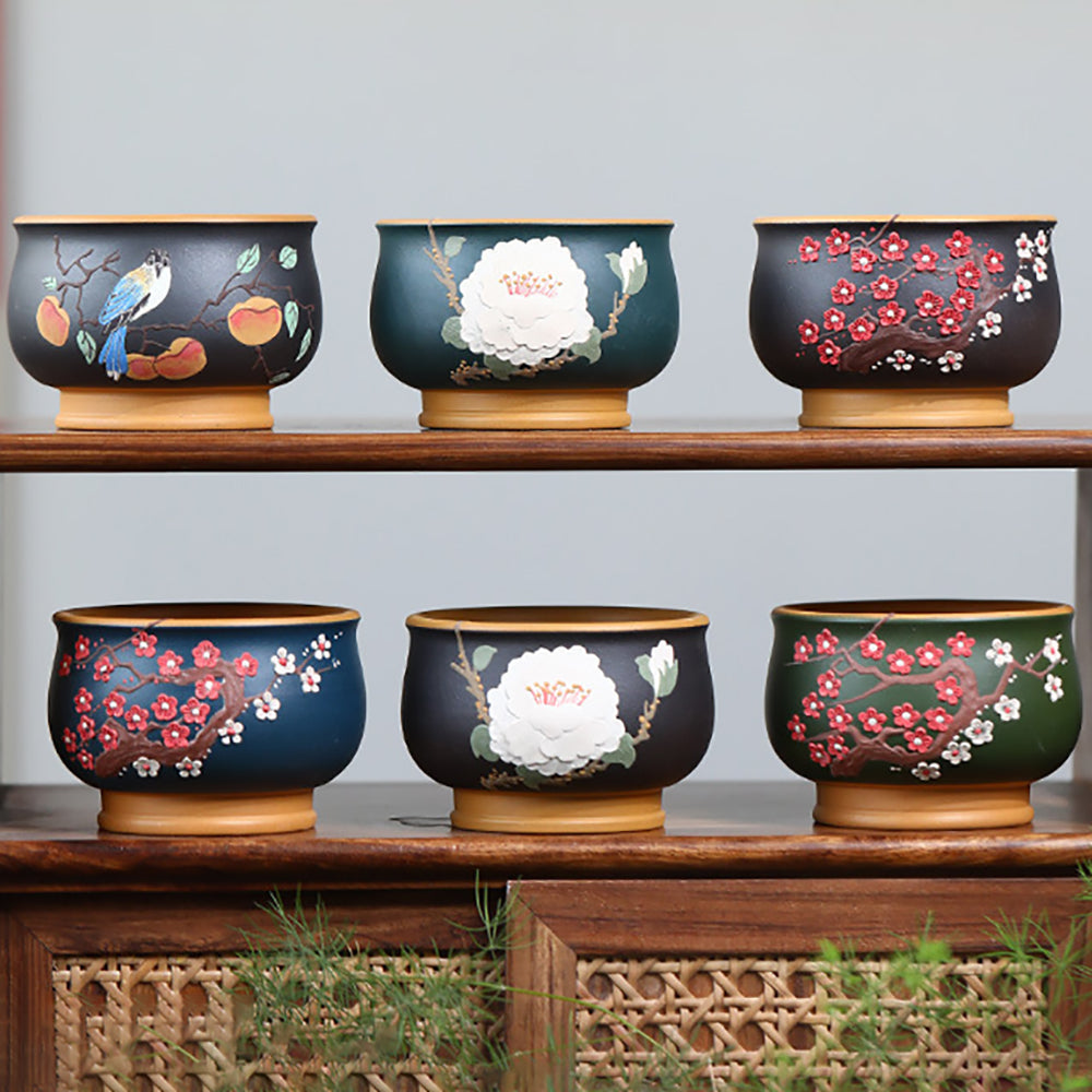 Close-up view of the purple clay tea cup set featuring detailed flower and bird designs.