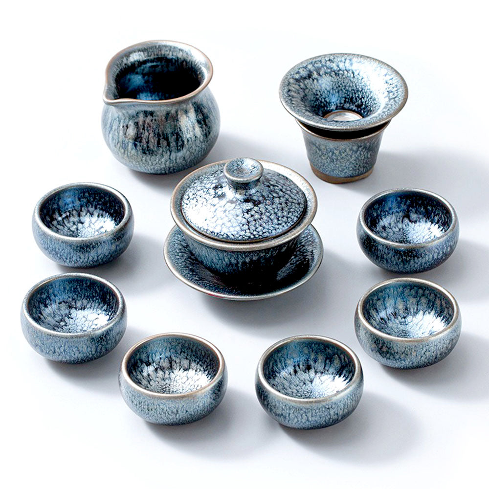 Artisan Tenmoku Tianmu Jian Zhan tea set displayed on a wooden table, highlighting its elegant design and craftsmanship.
