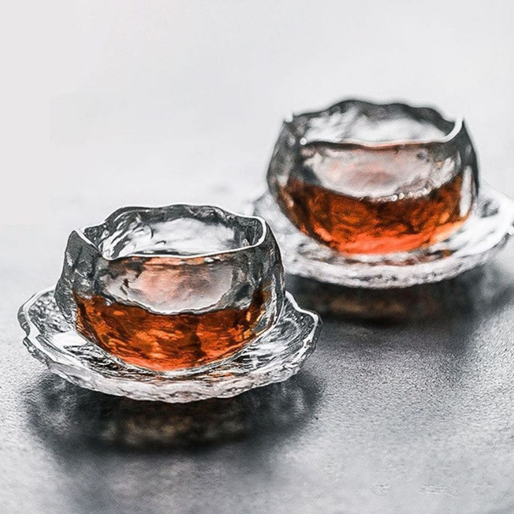 Overhead view of the tea cup with saucer highlighting the glass mug’s artistic ice-block design.
