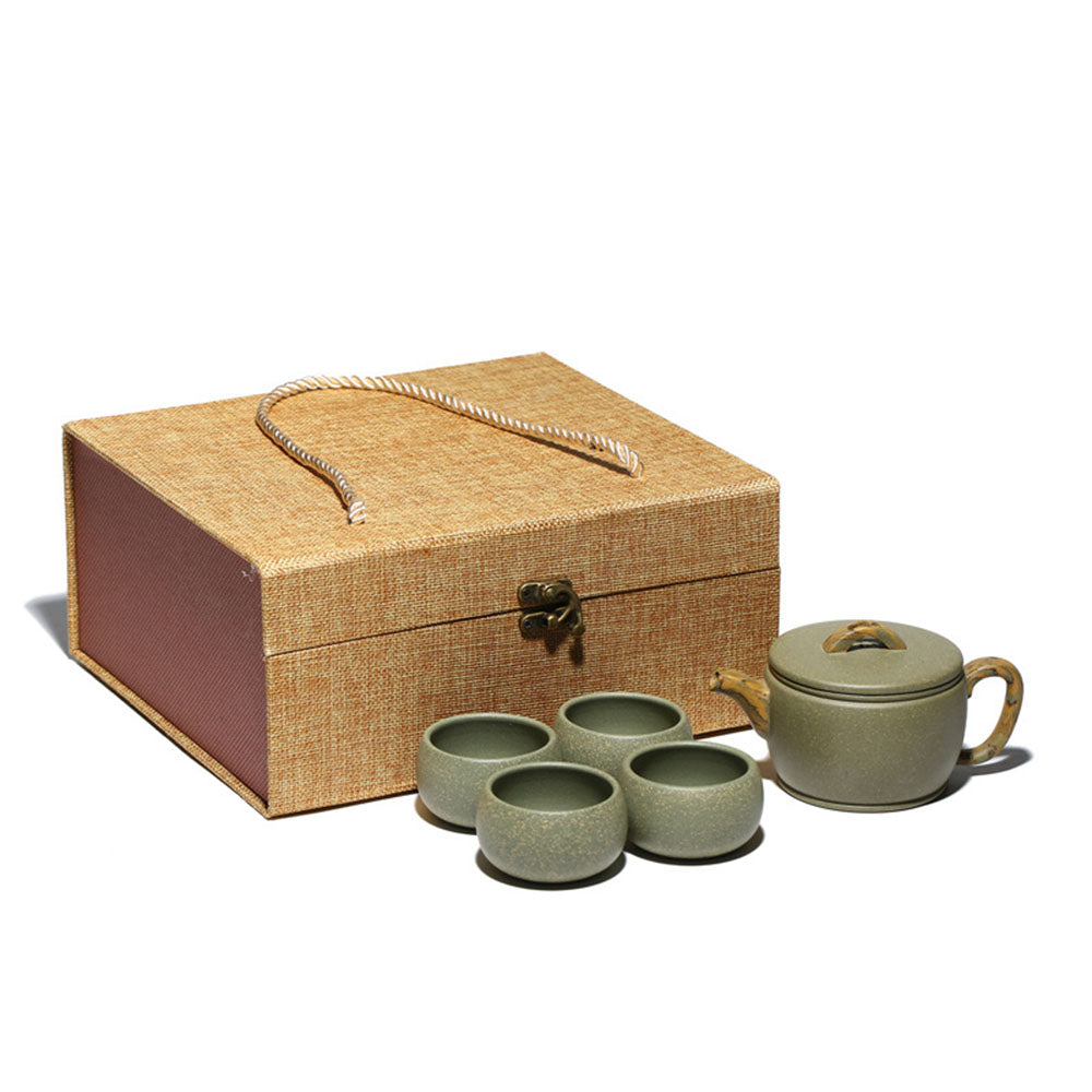 Close-up of handmade Yixing green clay teapot with smooth, rounded body and curved spout