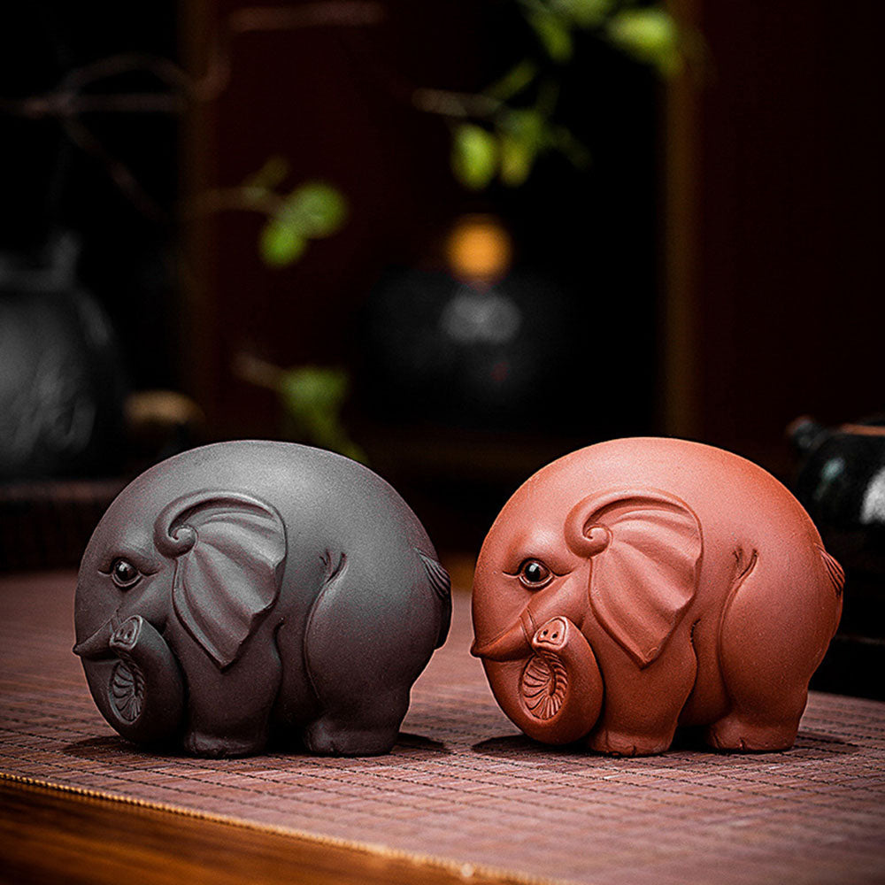 Yixing clay elephant tea pet on a tea tray with tea leaves