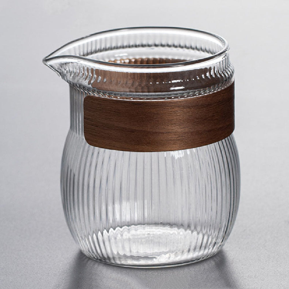 Side view of glass fair cup with wooden handle for tea serving