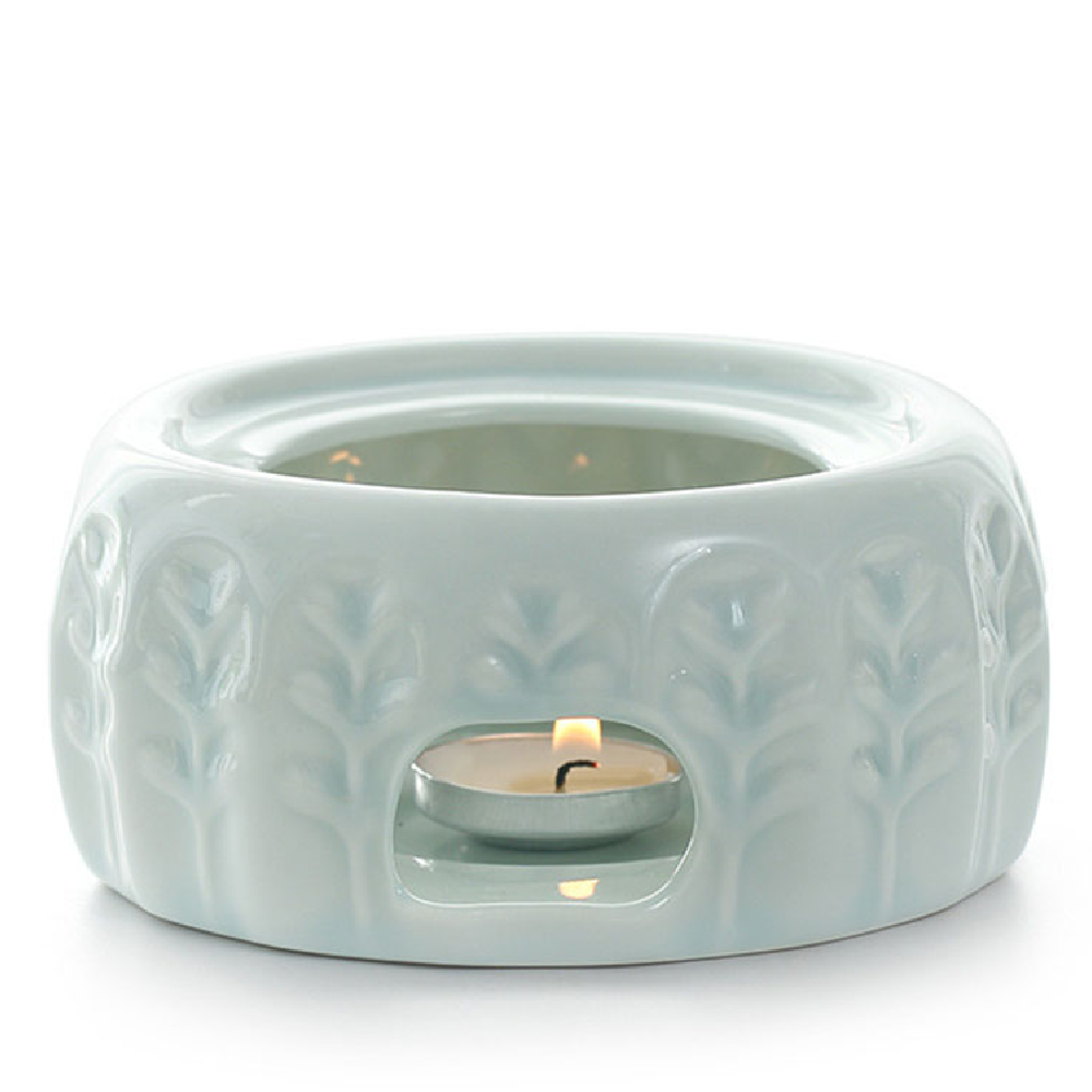 Side view of ceramic tea warmer with teapot, showing candle placement