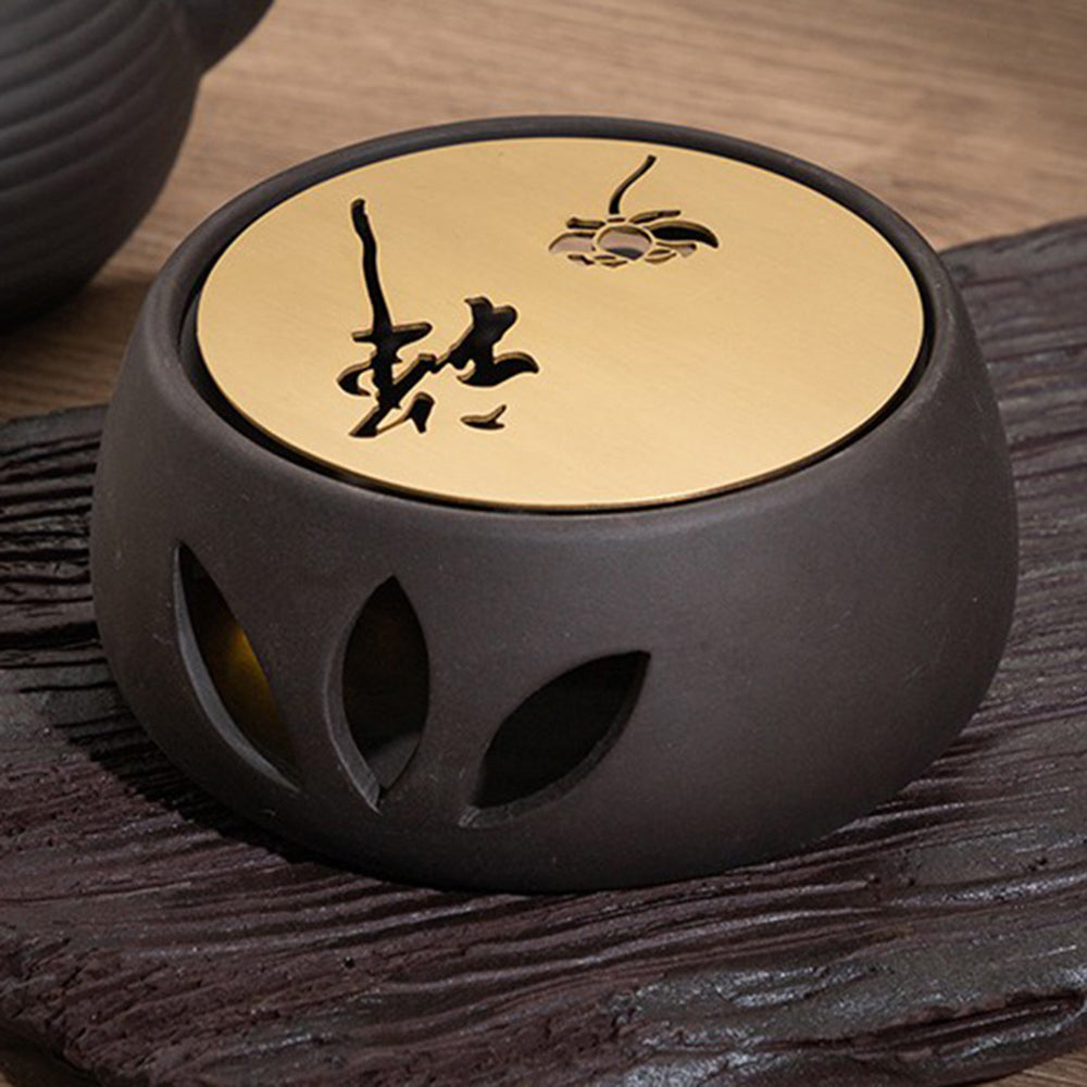 Elegant clay teapot warmer with copper plate showcasing its smooth finish and design.