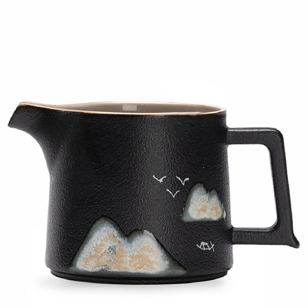 Close-up of Japanese mountain ceramic fair cup with textured glaze and mountain landscape design