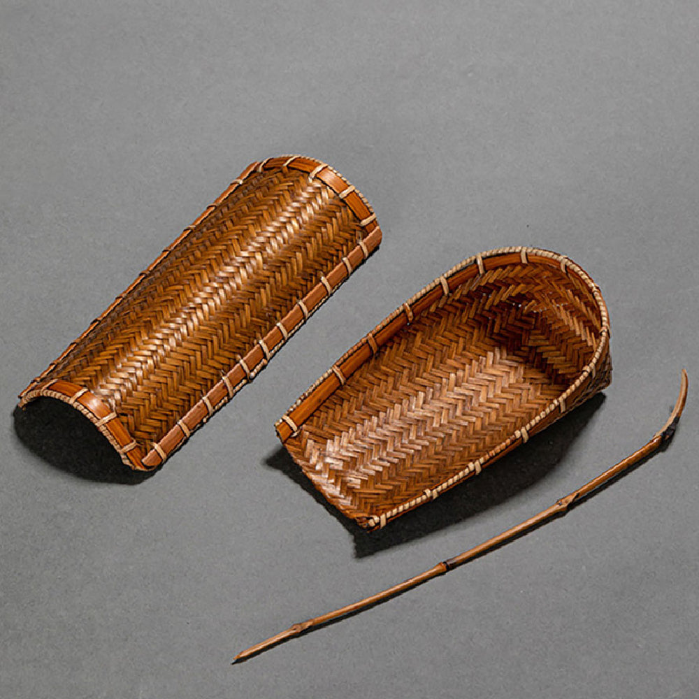 Elegant bamboo tea holder with spoon displayed with dry tea leaves in a cozy setting.