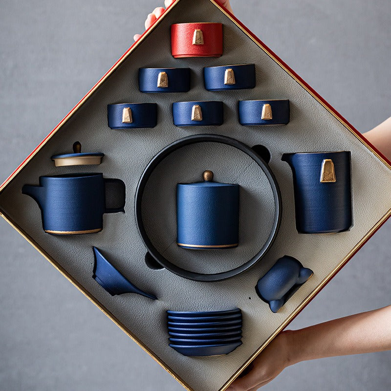 Elegant blue tea set with golden handles on a wooden table, showcasing its artistic design.