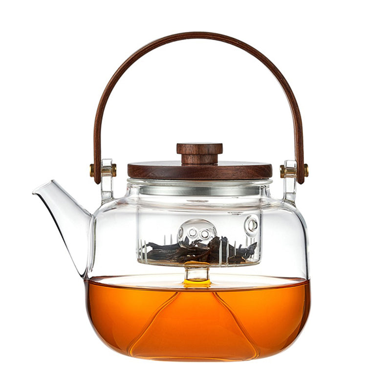 Elegant heat resistant glass teapot with infuser showcasing blooming tea leaves.