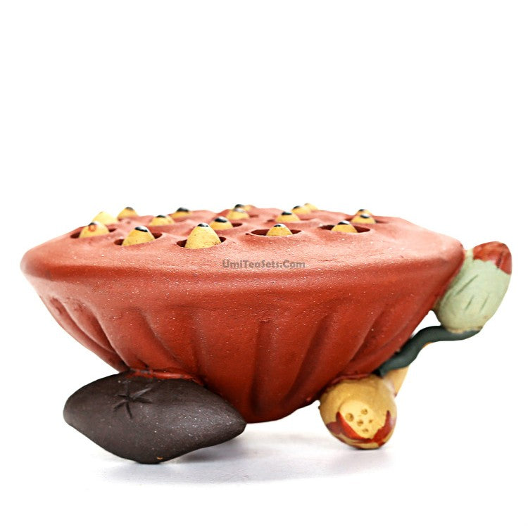 Yixing clay lotus seedpod water spray tea pet on tea tray, showcasing traditional craftsmanship