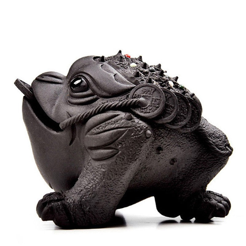 Yixing clay toad tea pet sitting on a traditional tea tray, showcasing intricate craftsmanship