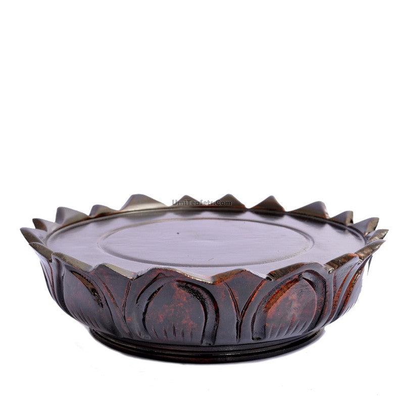 Artistic wooden teapot stand with lotus design on a tea table