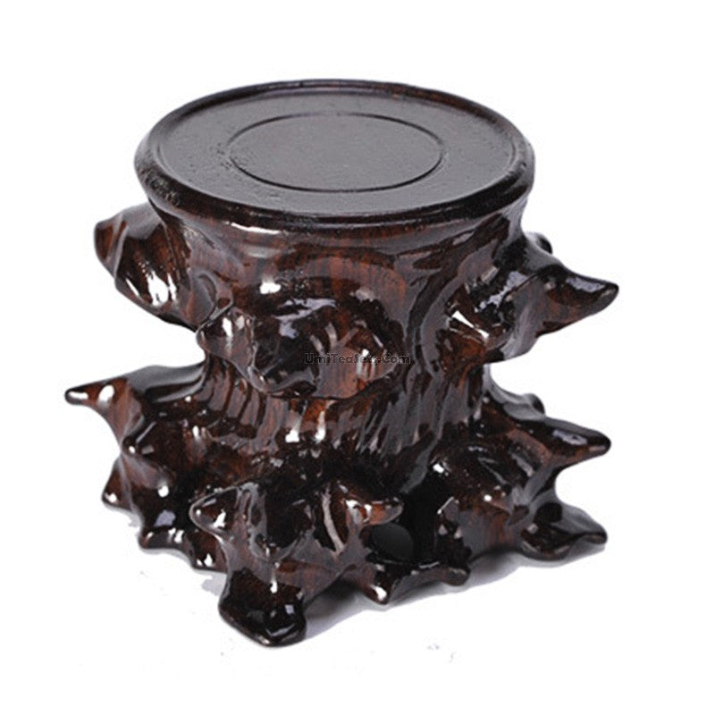 Close-up of black wood teapot stand showcasing unique textured surface